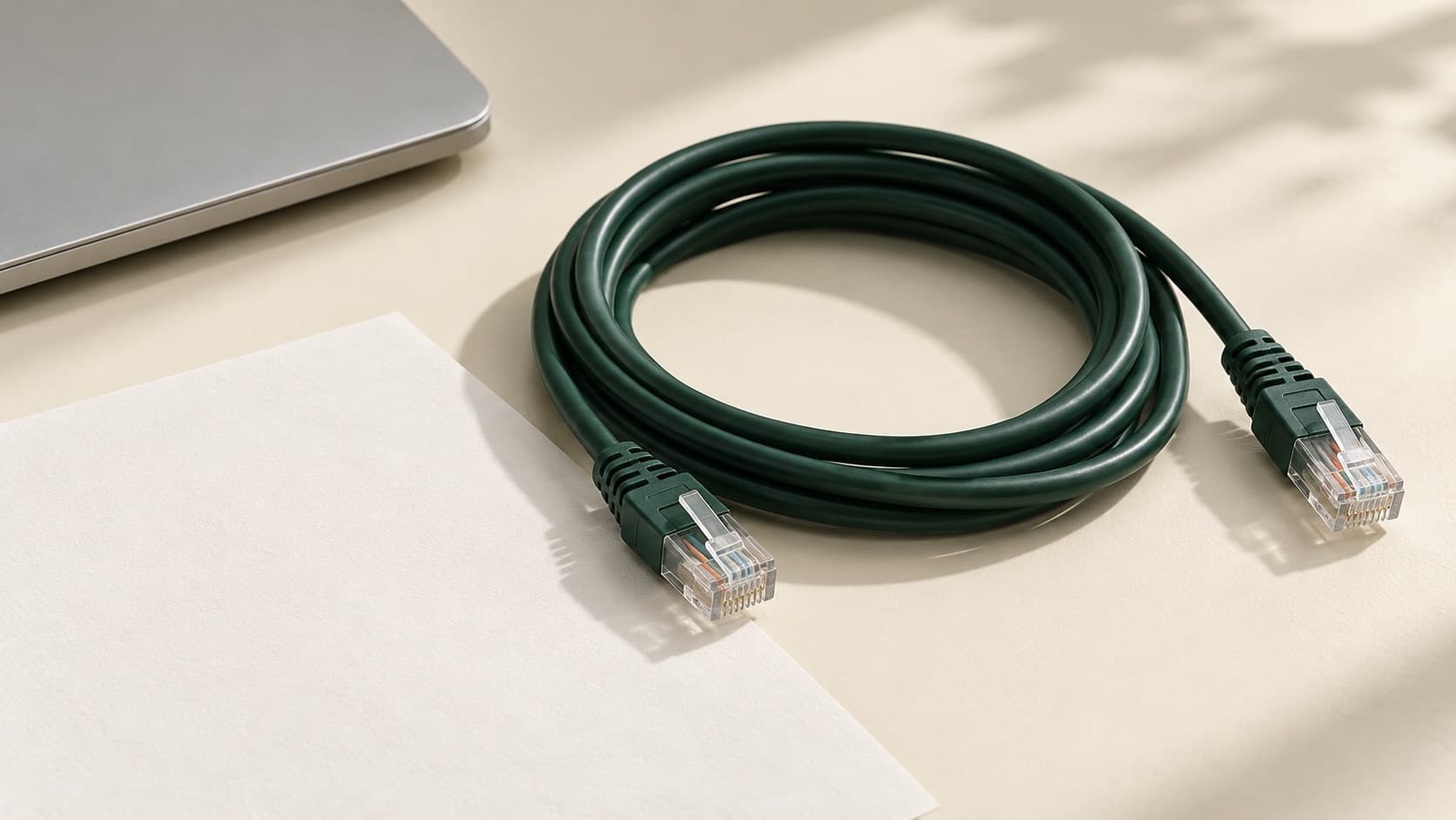 An Ethernet cable and laptop ready for a wired connection comparison